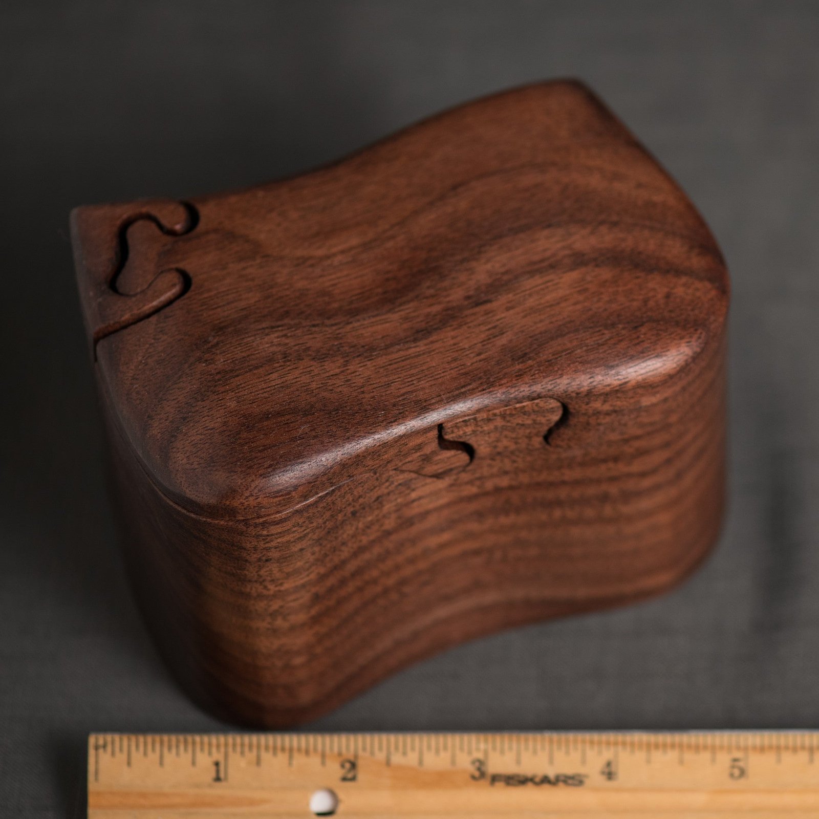 Dark wood bandsawn puzzle box with interior tray and a ruler for scale, by Designs by Baerreis